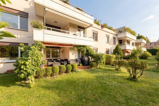 view of home with a balcony, stucco siding, a yard, and a patio