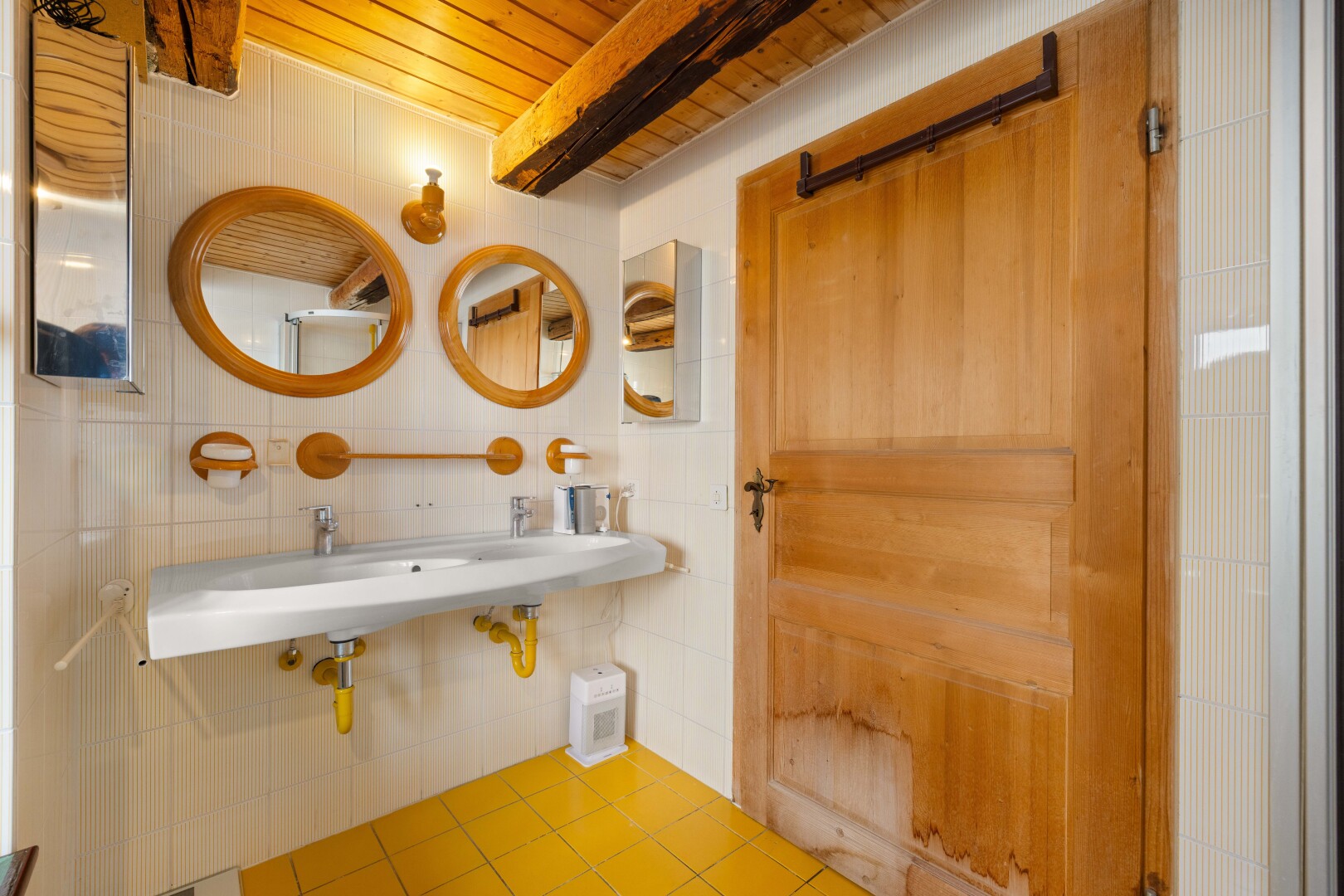 salle de bains avec miroir, plafond en bois, wood ceiling, évier, et sol en carrelage