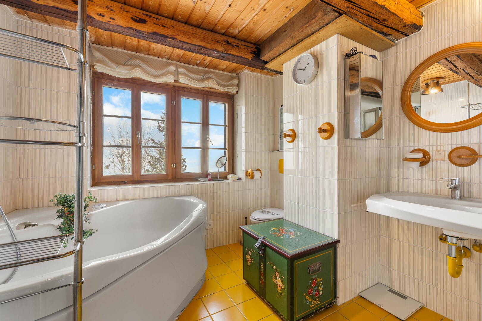 salle de bains avec mur en carrelage, tile wall, bain, miroir, et lumière naturelle