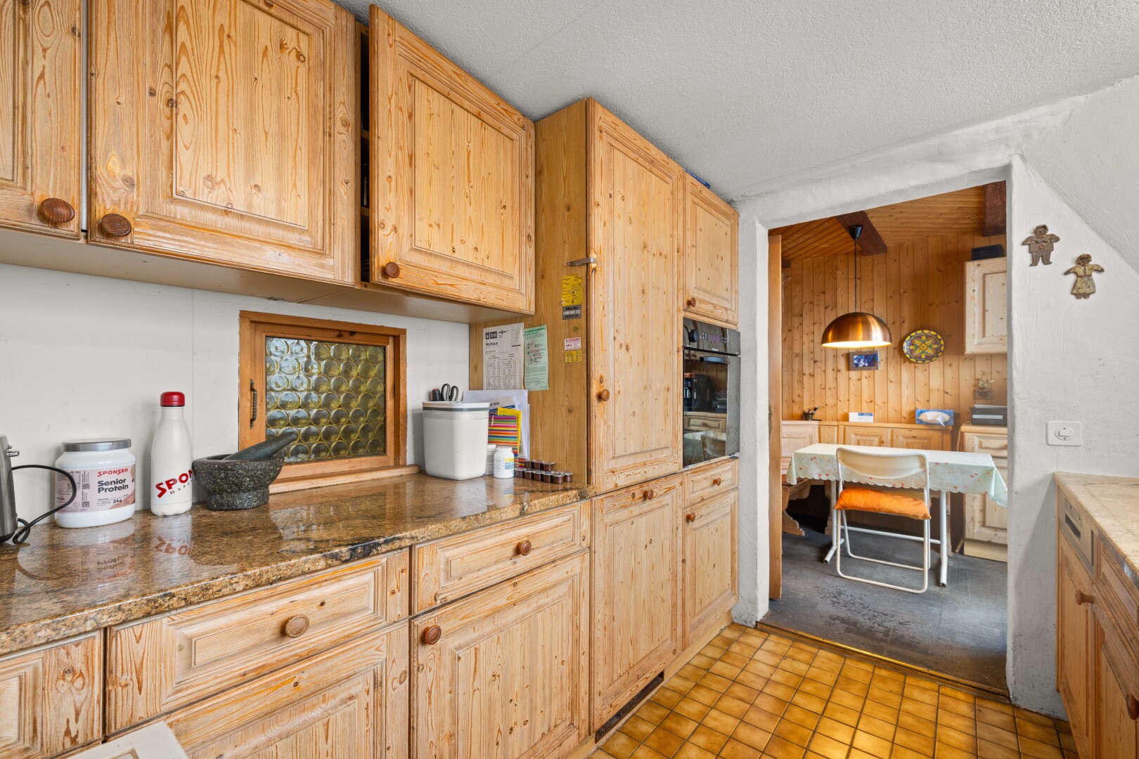cuisine avec armoires élevées, raised cabinets, light floor, inside property, et armoires marron clair