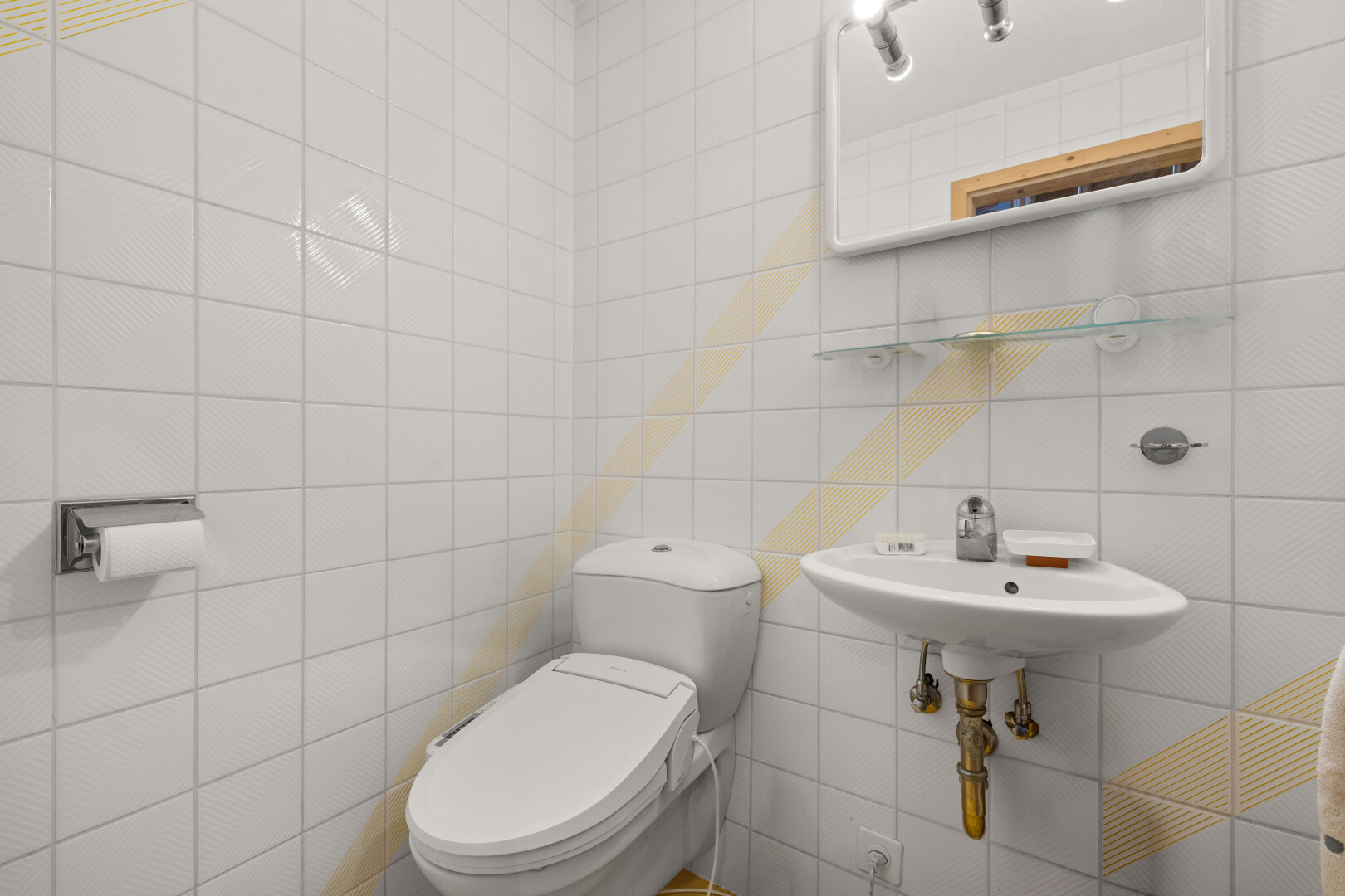 salle de bains avec miroir, toilette, mur en carrelage, tile wall, et inside property