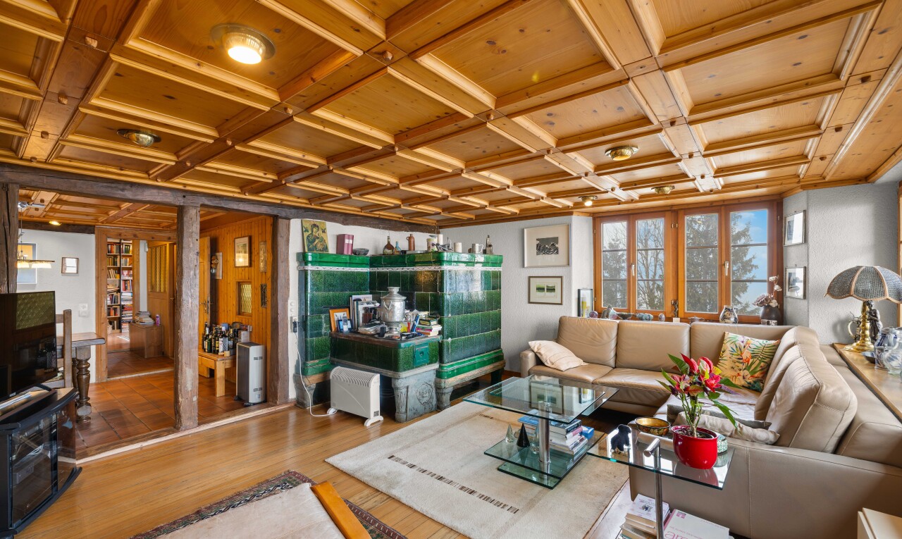 salon avec coffered ceiling, plafond à caissons, inside property, télévision, et wood finish floor
