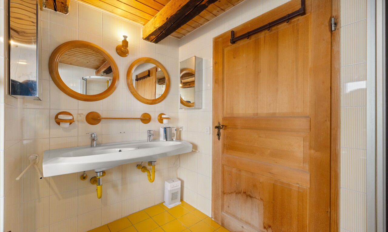 salle de bains avec miroir, plafond en bois, wood ceiling, évier, et sol en carrelage