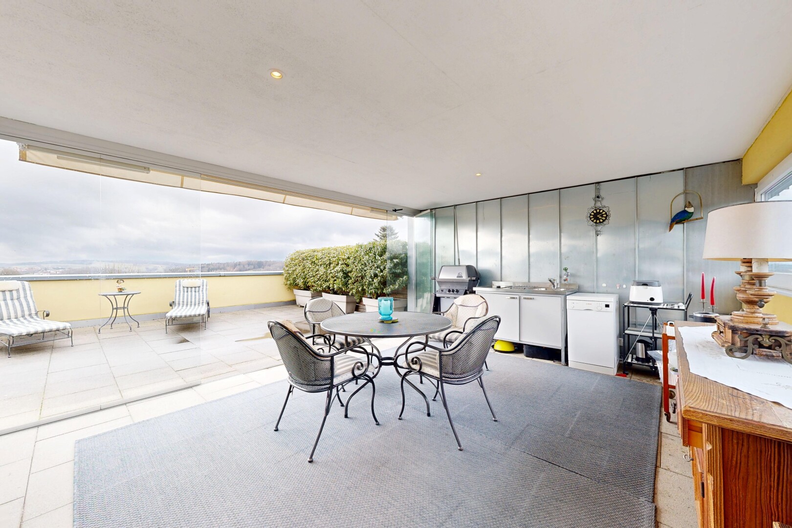 terrace with an outdoor kitchen / dining area and a patio