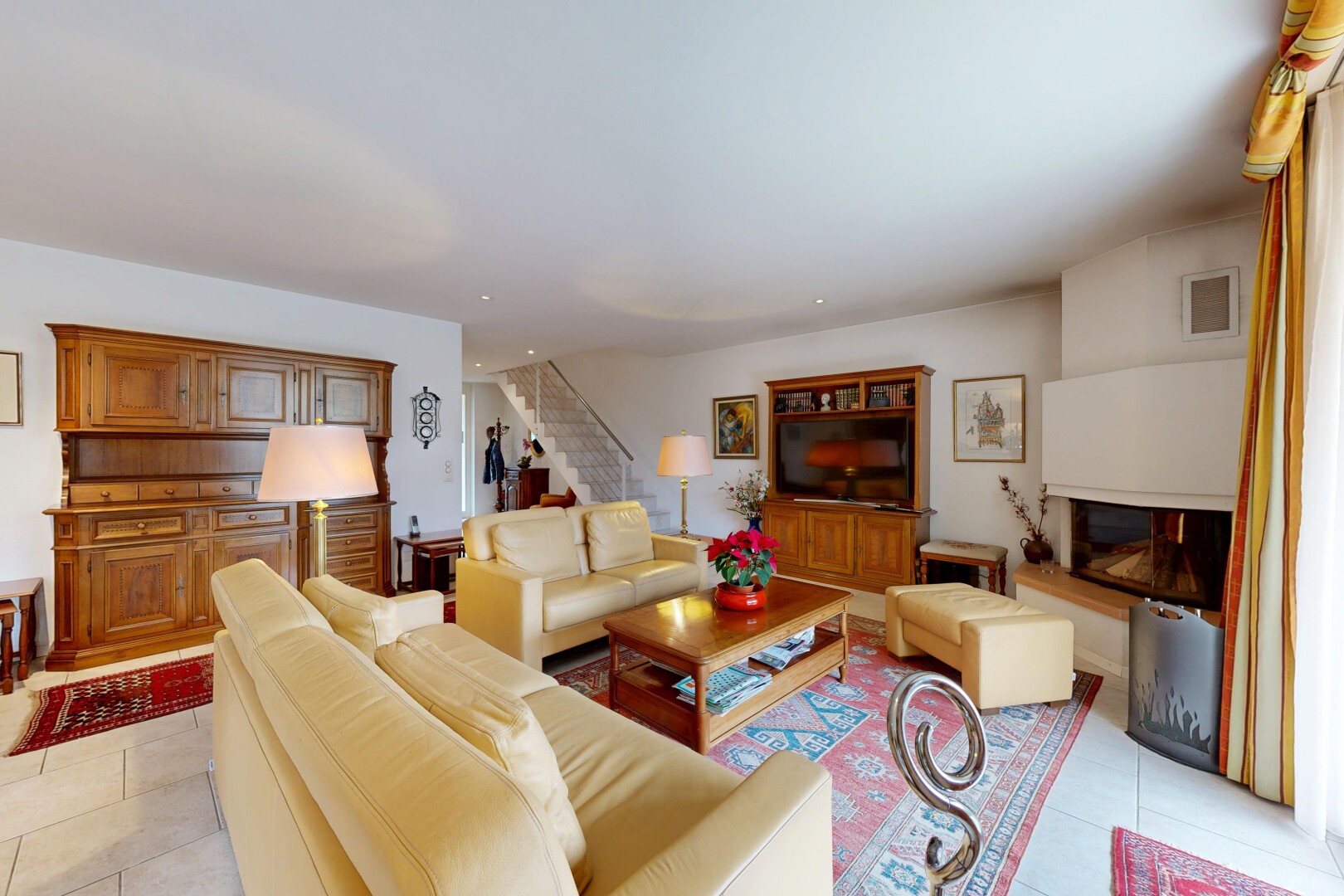living area featuring light tile patterned flooring and stairs