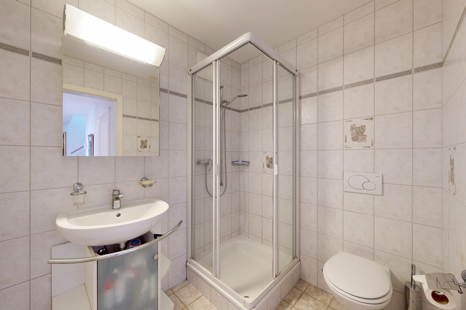 bathroom with tile walls, a shower stall, and tile patterned flooring