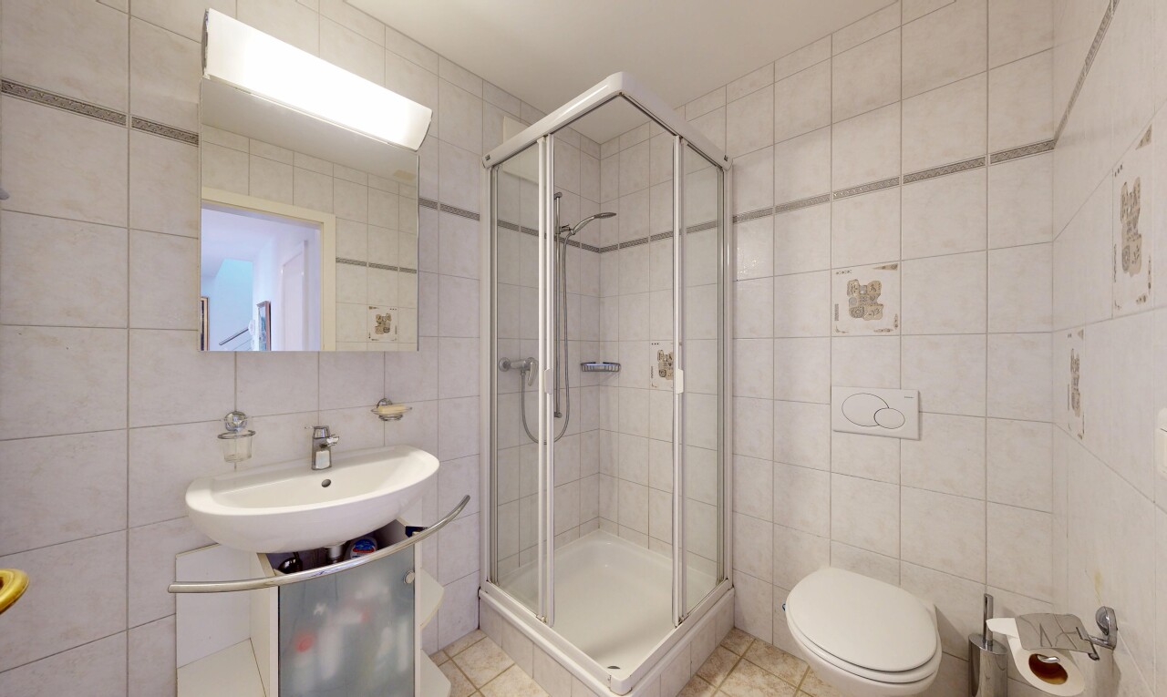 bathroom with tile walls, a shower stall, and tile patterned flooring