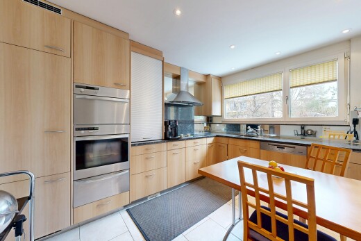 cuisine avec armoires marron clair, light brown cabinets, tiroir chauffant, armoires à panneau plat, et flat panel cabinets