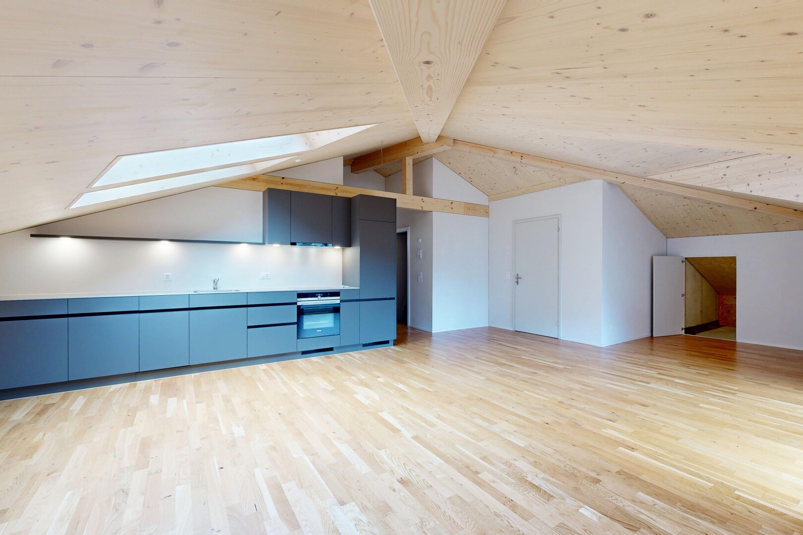 pièce vide avec wood finish floor, sol en finition bois, beamed ceiling, plafond à poutres, et drywall