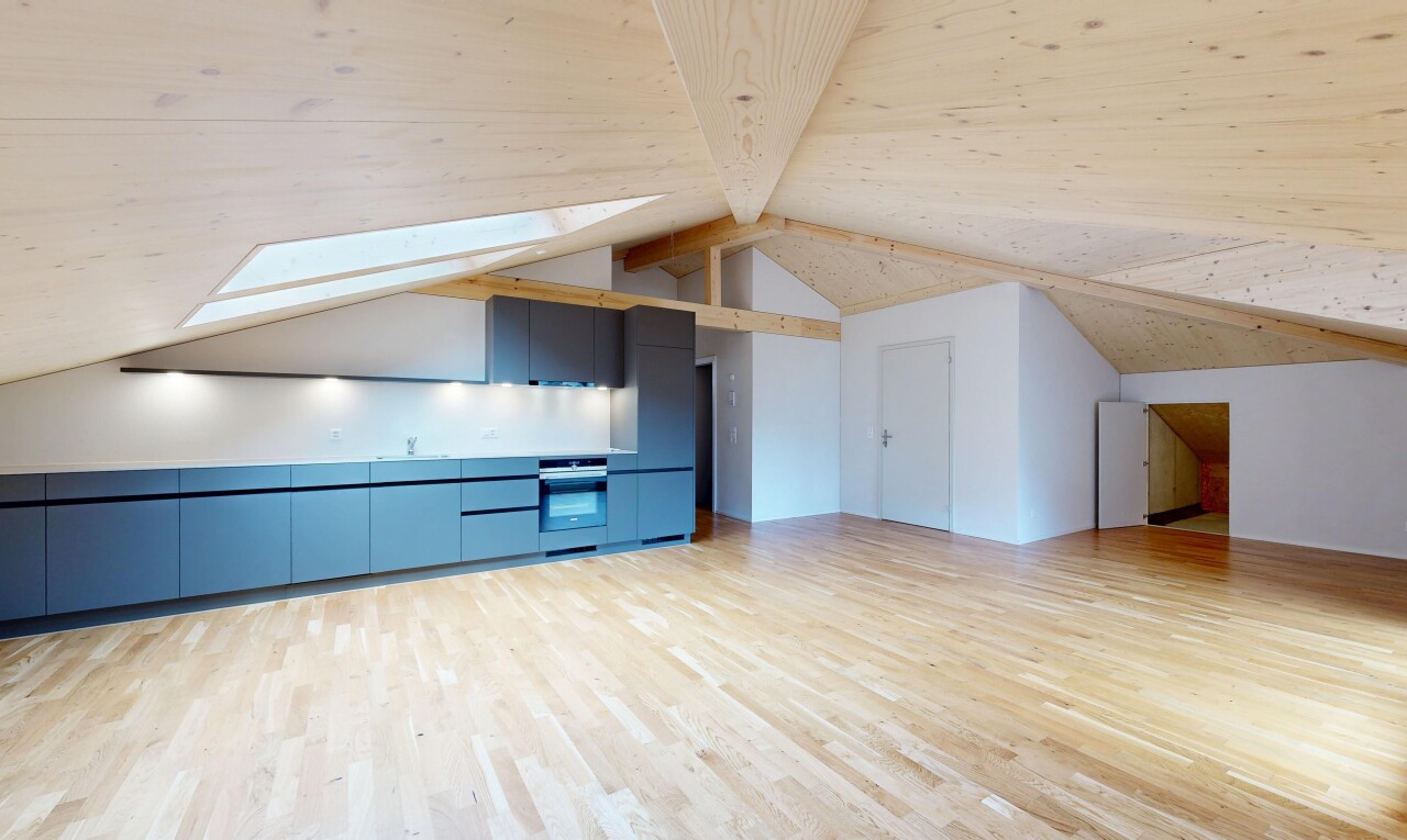 pièce vide avec wood finish floor, sol en finition bois, beamed ceiling, plafond à poutres, et drywall