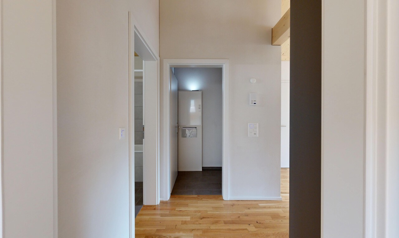couloir avec sol en finition bois, wood finish floor, cloison sèche, drywall, et inside property