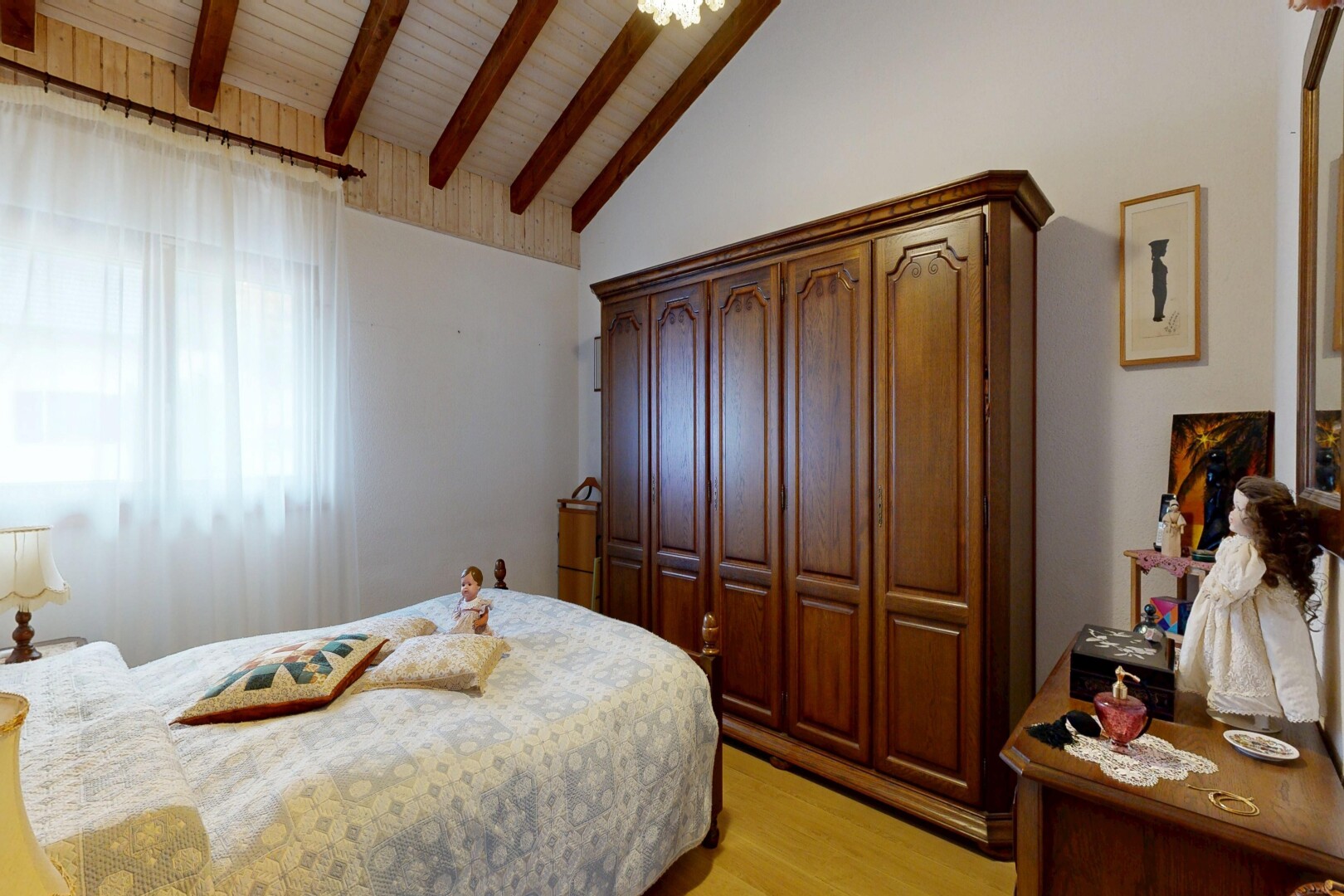 chambre avec sol en finition bois, wood finish floor, inside property, plafond voûté, et vaulted ceiling