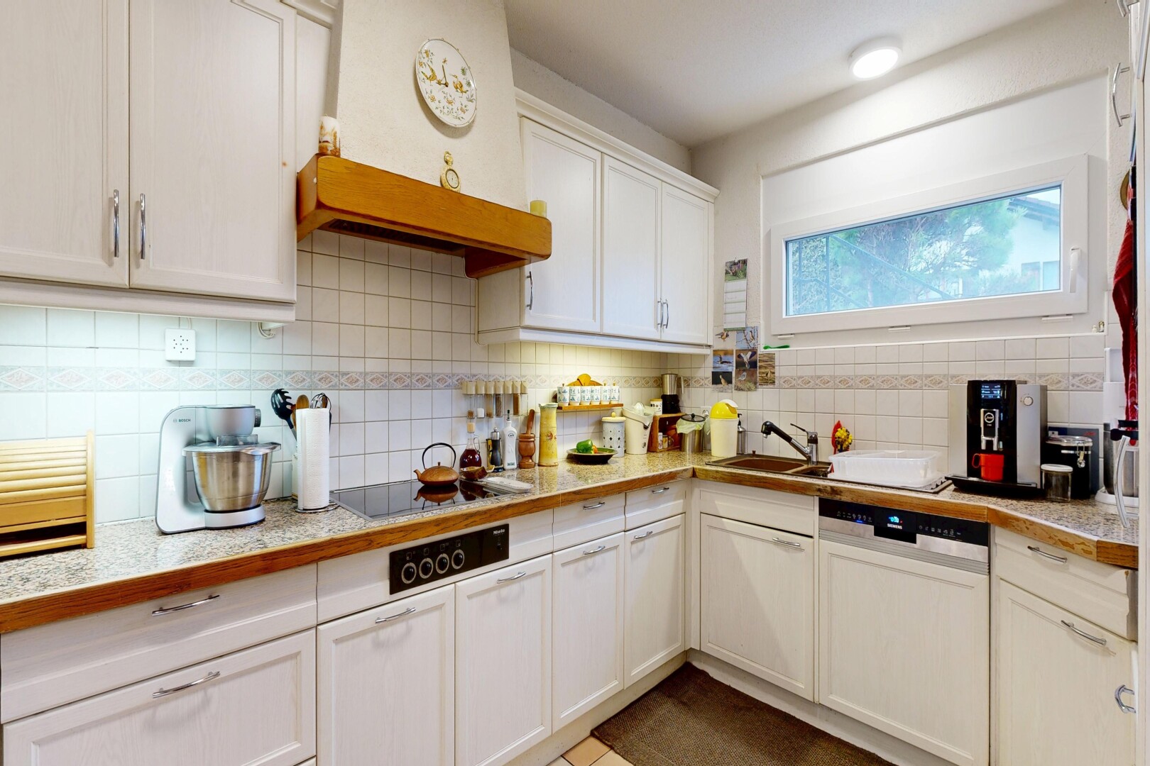 cuisine avec wood edge countertops, armoires avec moulures, crown molding cabinets, hotte, et armoires blanches