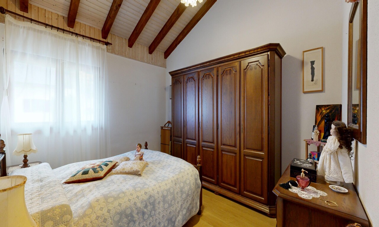 chambre avec sol en finition bois, wood finish floor, inside property, plafond voûté, et vaulted ceiling
