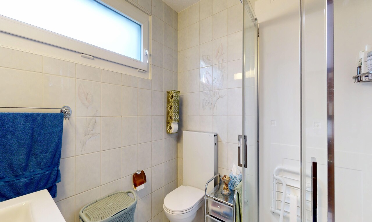 salle de bains avec douche, salle de bain complète, toilette, mur en carrelage, et tile wall