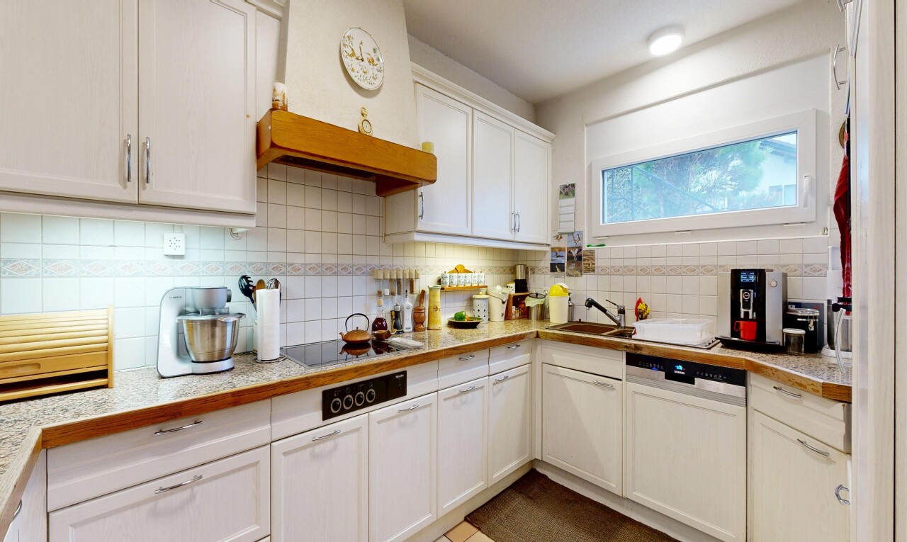 cuisine avec wood edge countertops, armoires avec moulures, crown molding cabinets, hotte, et armoires blanches