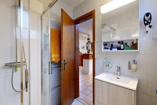 salle de bains avec tile wall, mur en carrelage, douche, miroir, et lavabo (ou coiffeuse selon le contexte)