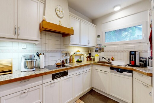 cuisine avec wood edge countertops, armoires avec moulures, crown molding cabinets, hotte, et armoires blanches