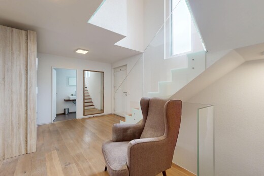 salon avec escaliers, wood finish floor, sol en finition bois, drywall, et cloison sèche