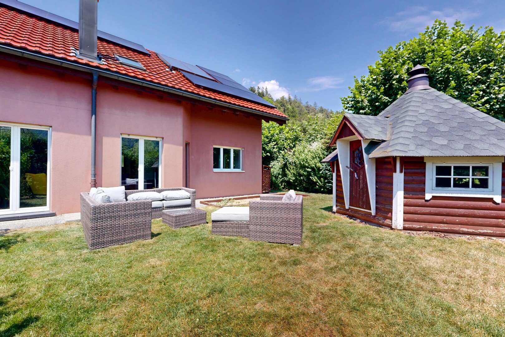 façade avec cheminée, panneaux solaires, espace de vie extérieur, from property, et structure extérieure
