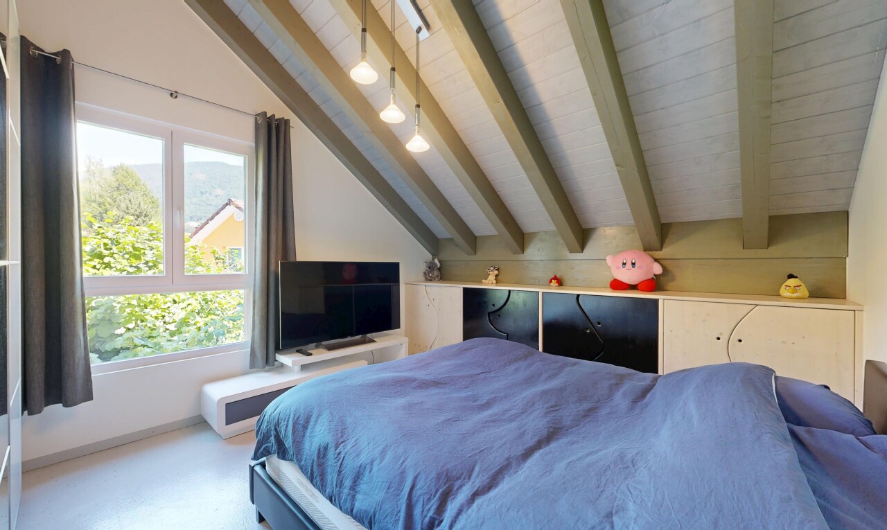 chambre avec inside property, cloison sèche, drywall, télévision, et plafond à poutres