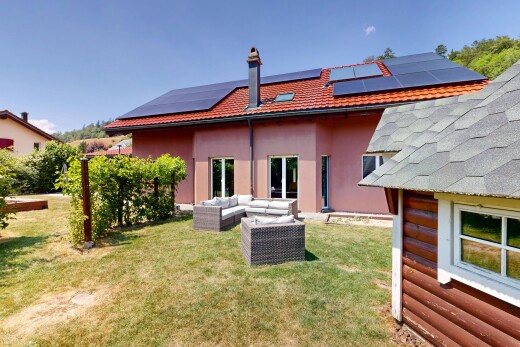 façade avec espace de vie extérieur, property visible, panneaux solaires, day time, et bardage en stuc