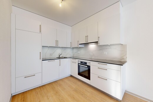 küche mit weiße schränke, arbeitsplatten, ofen, und küchenrückwand beim herd