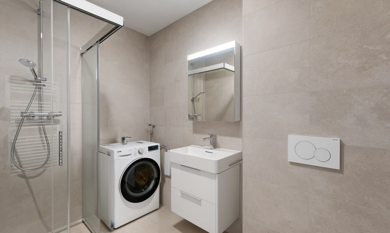 full bath with washer / dryer, vanity, a stall shower, and tile walls