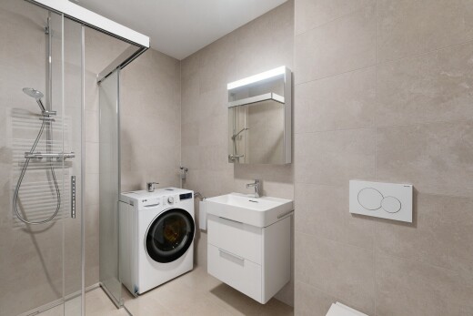salle de bains avec lave-linge et sèche-linge, miroir, lavabo (ou coiffeuse selon le contexte), salle de bain complète, et douche