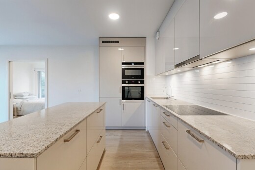 kitchen with a kitchen island, modern cabinets, light wood-style floors, light stone countertops, and recessed lighting