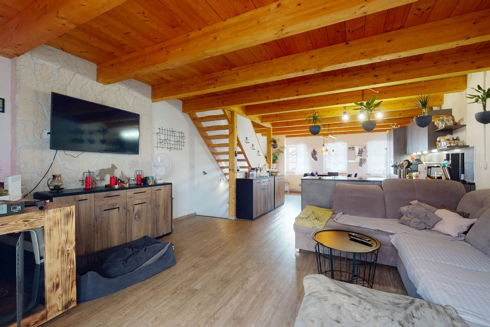 salon avec inside property, télévision, natural light, lumière naturelle, et wood finish floor
