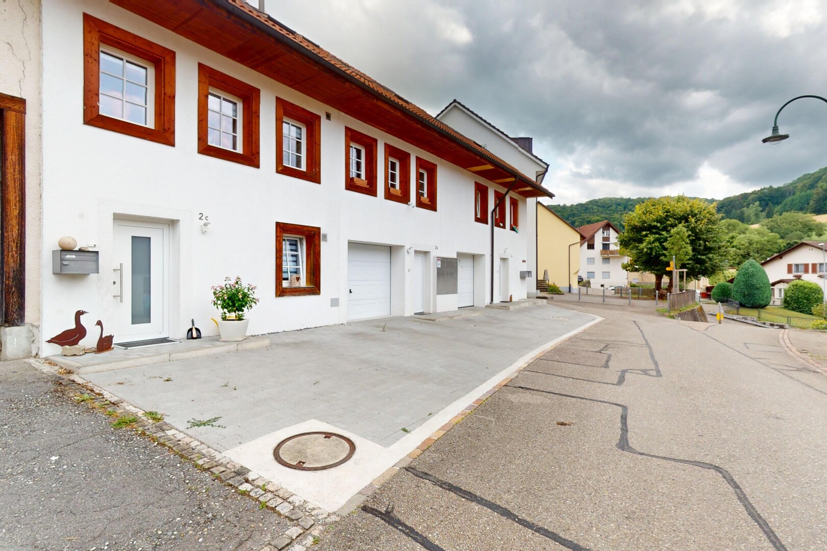 façade avec overcast, bardage en stuc, et garage intégré