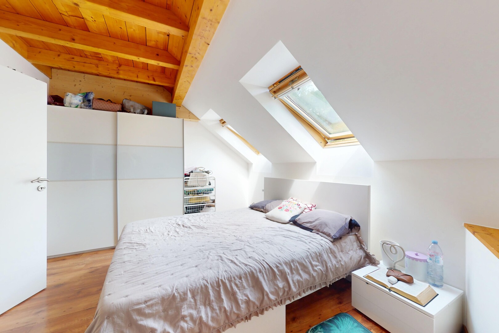 chambre avec pièce supplémentaire, puits de lumière, inside property, wood finish floor, et sol en finition bois