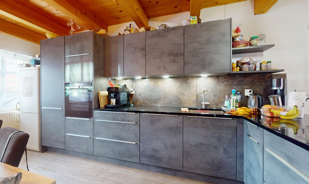 cuisine avec plafond à poutres, beamed ceiling, armoires à panneau plat, réfrigérateur, et four