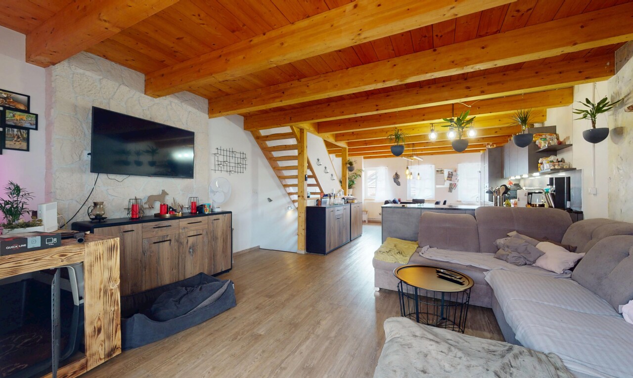 salon avec inside property, télévision, natural light, lumière naturelle, et wood finish floor