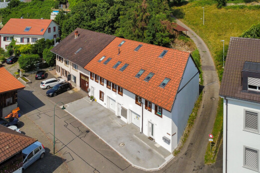 außenansicht mit stuckverkleidung, eingebaute garage, auffahrt, schindeldach, und drone view