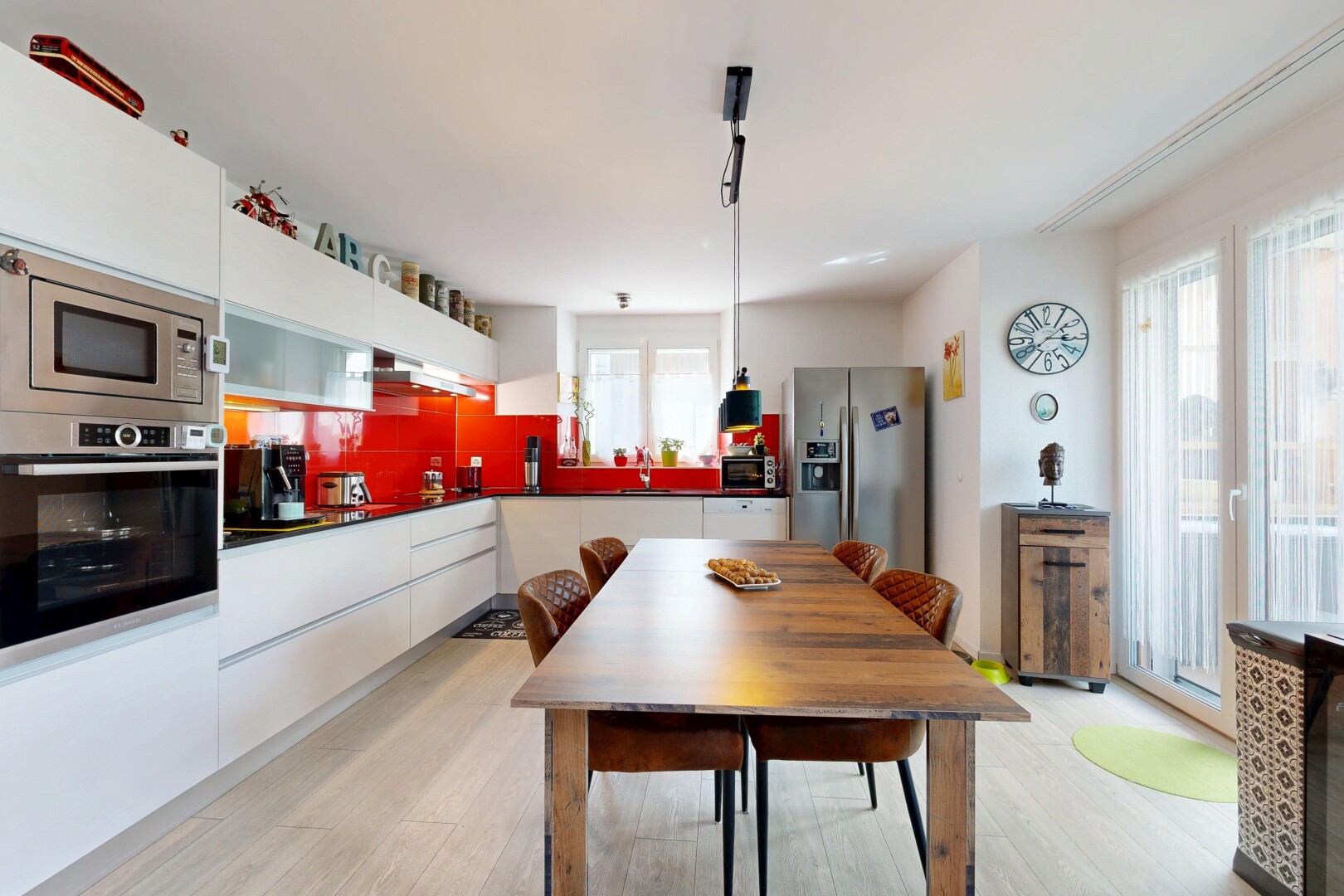 kitchen featuring appliances with stainless steel finishes, light wood-style floors, pendant lighting, dark countertops, and white cabinetry