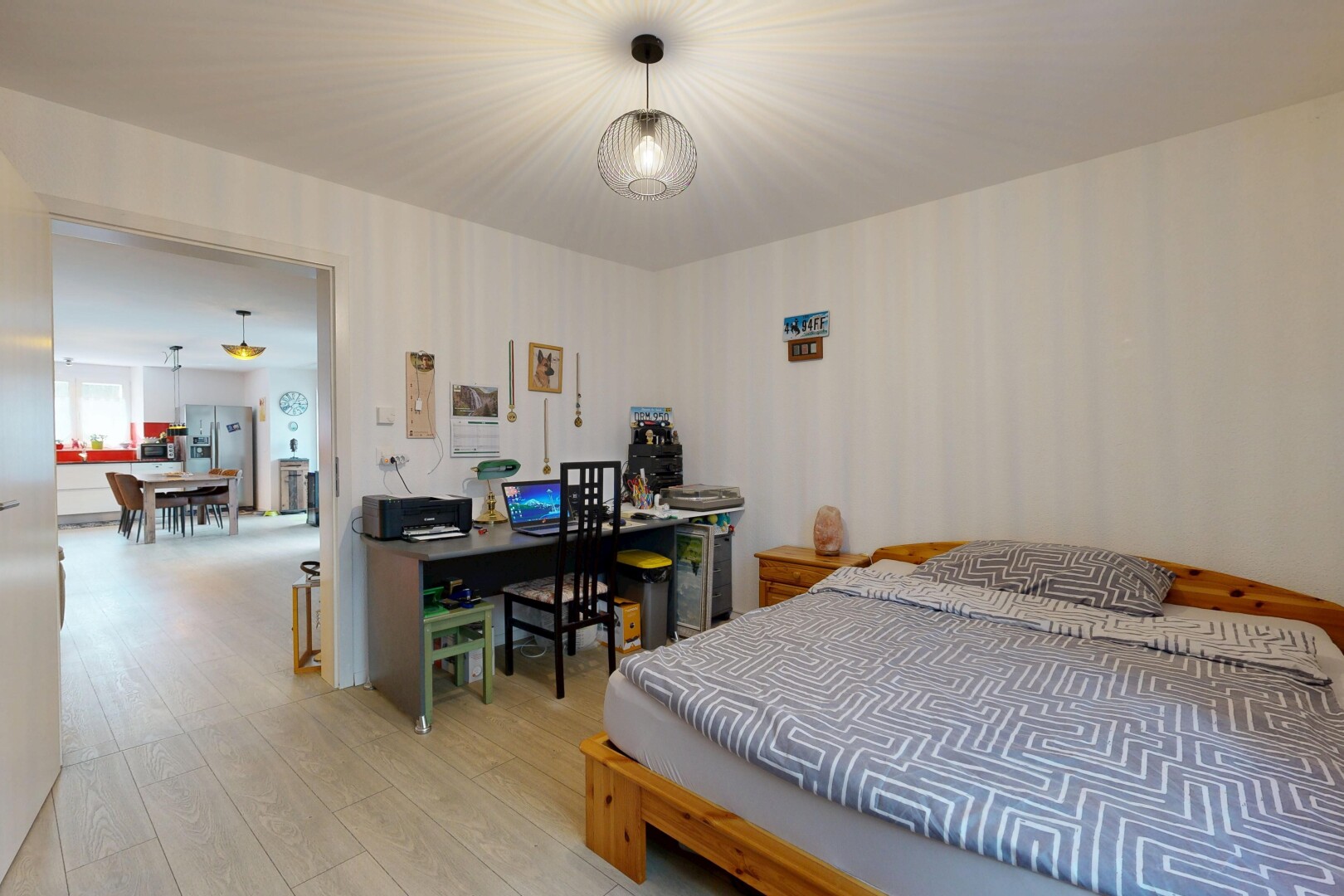 room / bedroom featuring wood finished floors, refrigerator with ice dispenser, and a desk