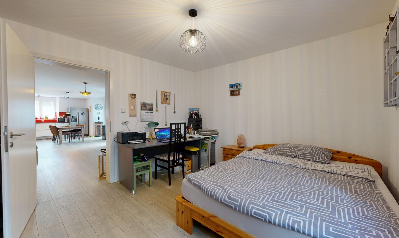 room / bedroom featuring wood finished floors, refrigerator with ice dispenser, and a desk