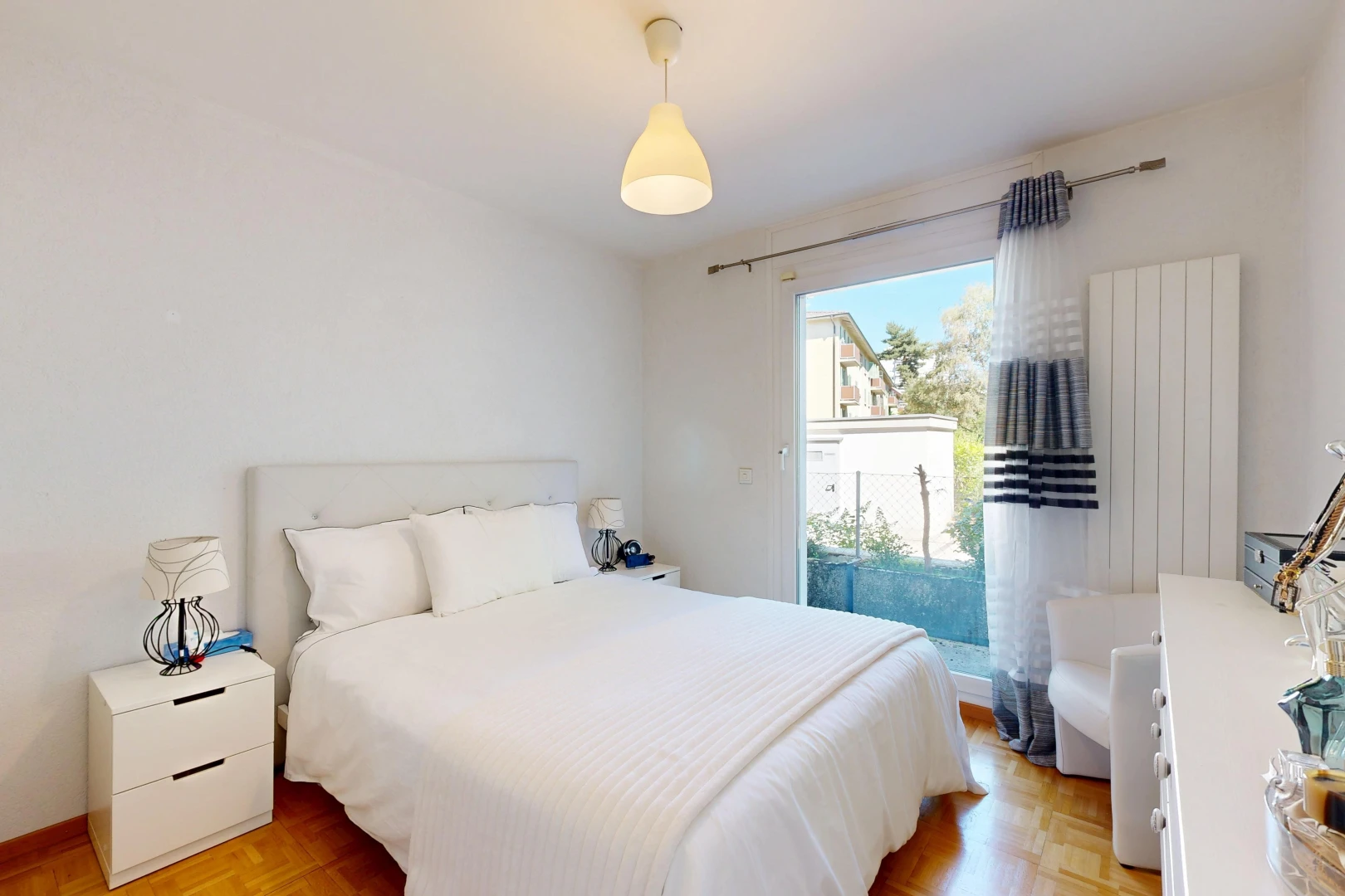 chambre avec éclairage suspendu, drywall, cloison sèche, wood finish floor, et sol en finition bois