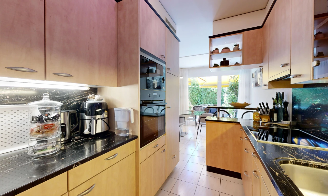 cuisine avec dark countertops, light floor, stone countertops, plans de travail en pierre, et plaque de cuisson
