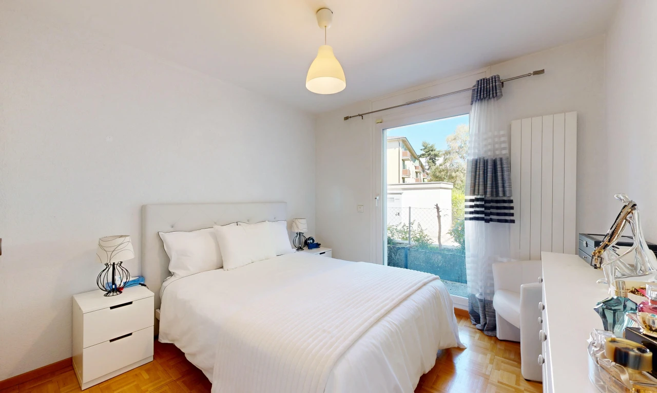 chambre avec éclairage suspendu, drywall, cloison sèche, wood finish floor, et sol en finition bois