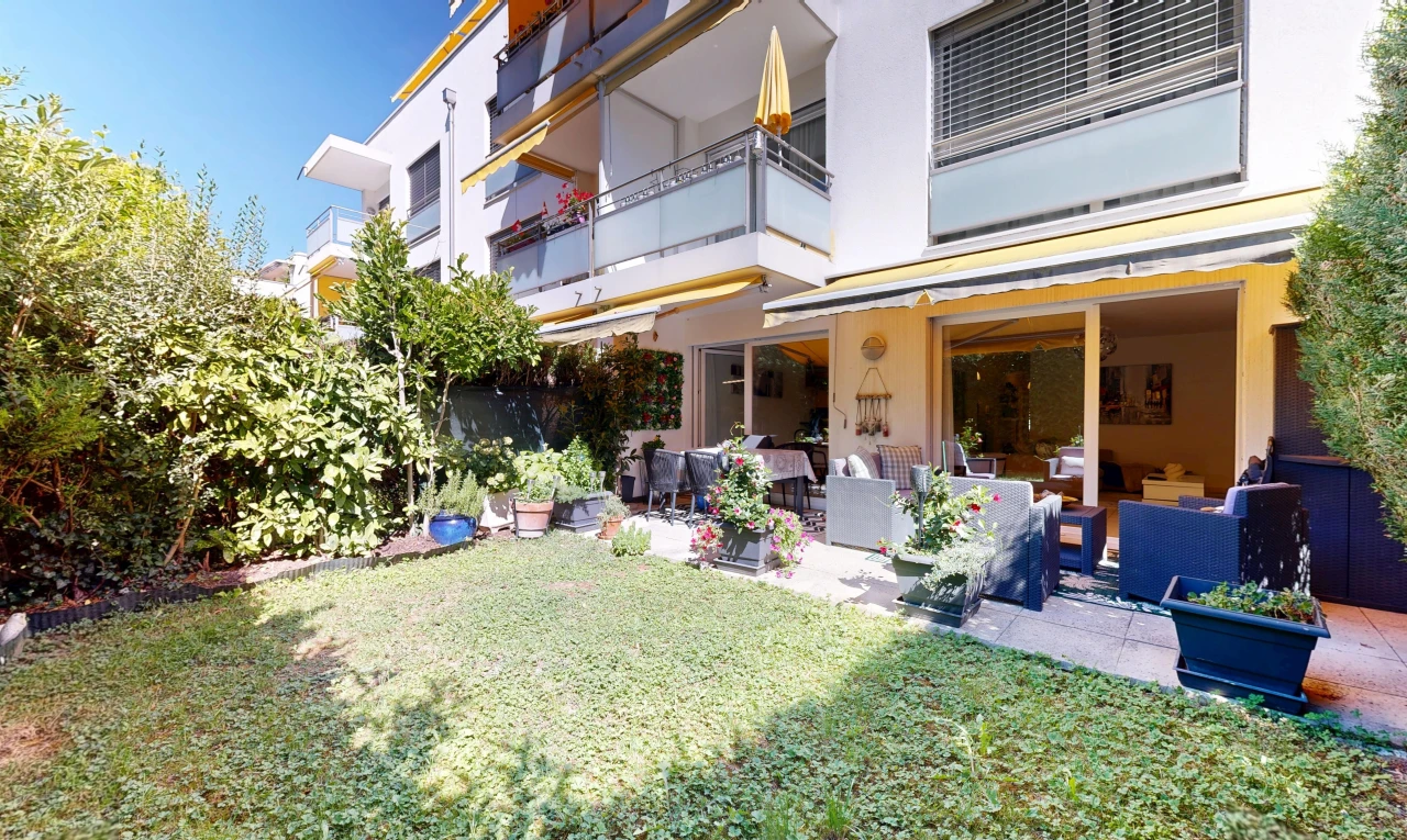 façade avec pelouse, balcon, espace de vie extérieur, auvent, et terrasse