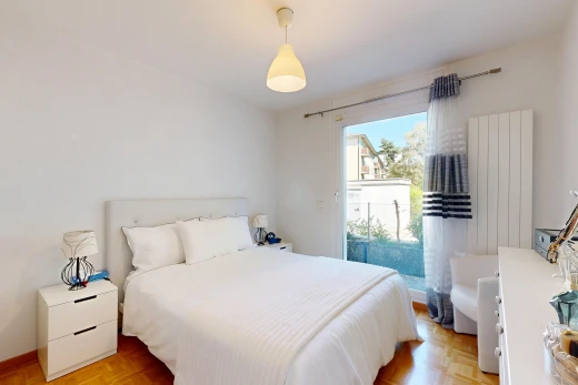 chambre avec éclairage suspendu, drywall, cloison sèche, wood finish floor, et sol en finition bois