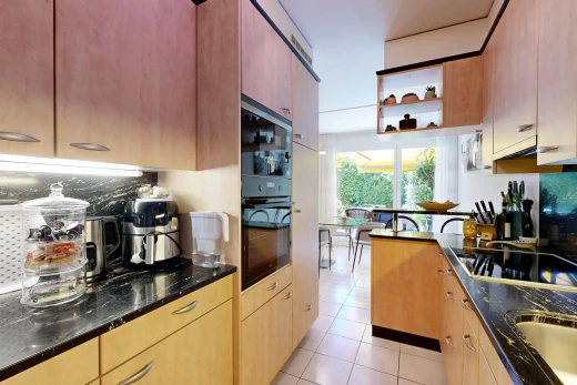 cuisine avec dark countertops, light floor, stone countertops, plans de travail en pierre, et plaque de cuisson