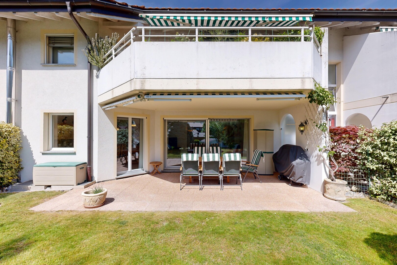 façade avec bardage en stuc, pelouse, balcon, terrasse, et day time