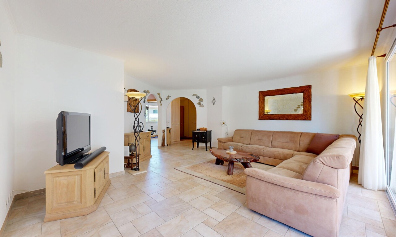 salon avec passages en arc, télévision, inside property, cloison sèche, et drywall