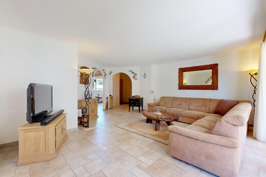 salon avec passages en arc, télévision, inside property, cloison sèche, et drywall