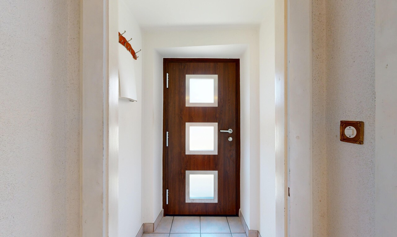couloir avec inside property, tile floor, sol en carrelage, drywall, et cloison sèche