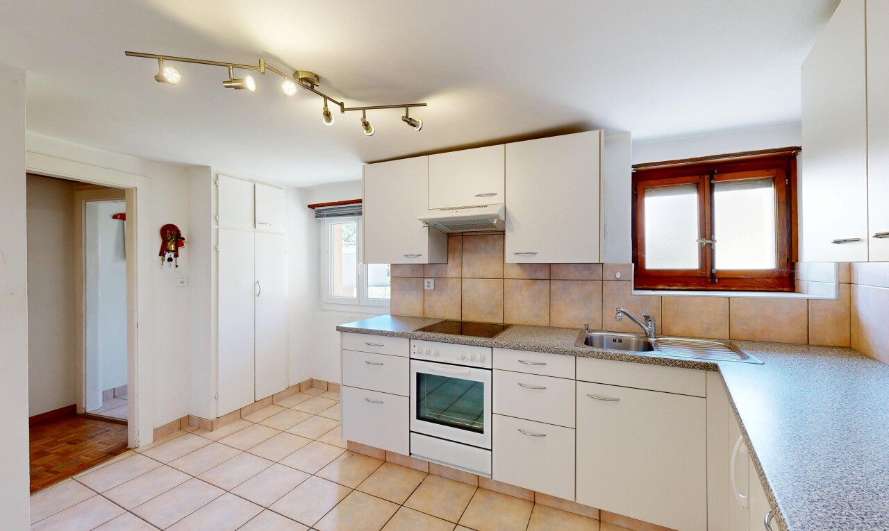 cuisine avec éclairage sur rail, light floor, light countertops, plans de travail, et backsplash